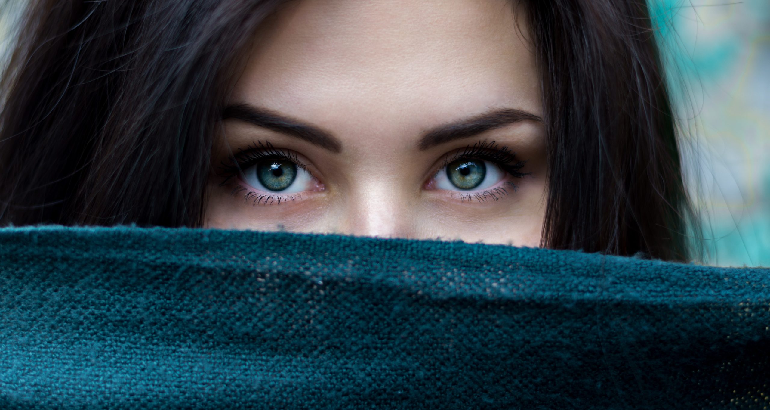 Woman's face behind scarf with only eyes visible